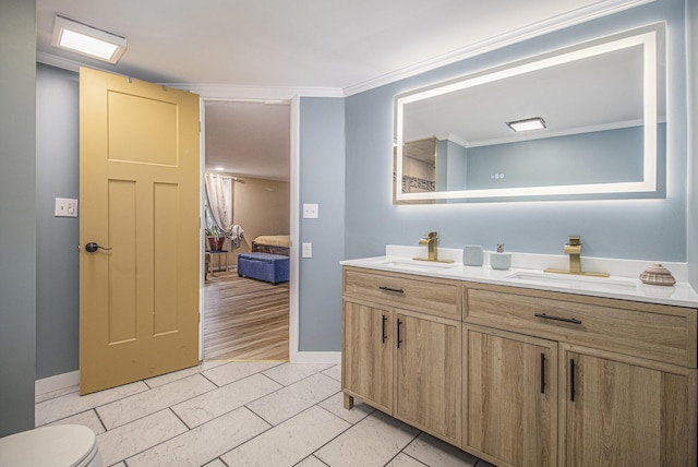 bathroom with crown molding, hardwood / wood-style floors, vanity, and toilet