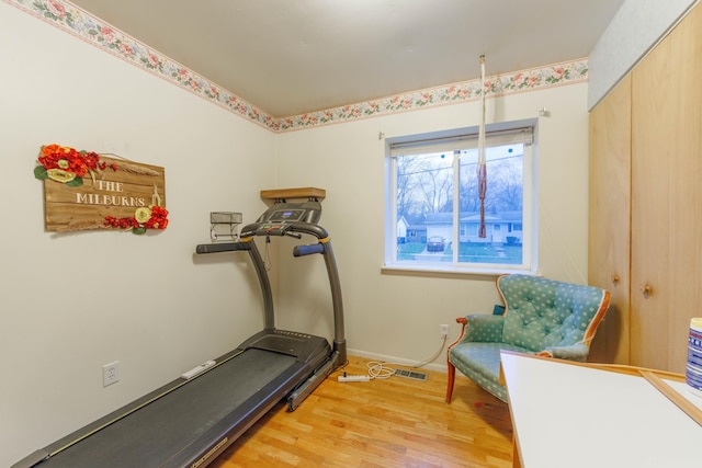 workout area with light hardwood / wood-style floors