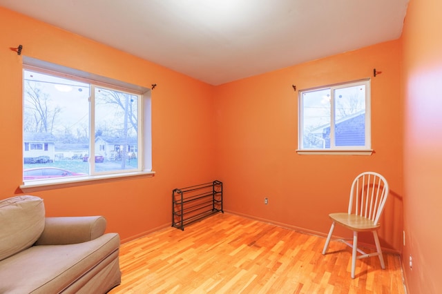 living area with a healthy amount of sunlight and light hardwood / wood-style flooring