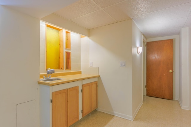 bathroom featuring a paneled ceiling and sink