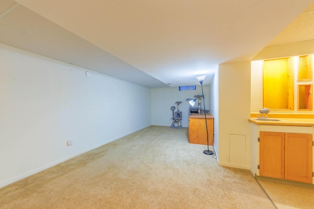 basement featuring light colored carpet and sink