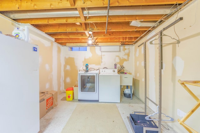 basement with separate washer and dryer and white fridge