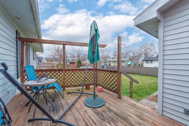 wooden deck featuring a lawn