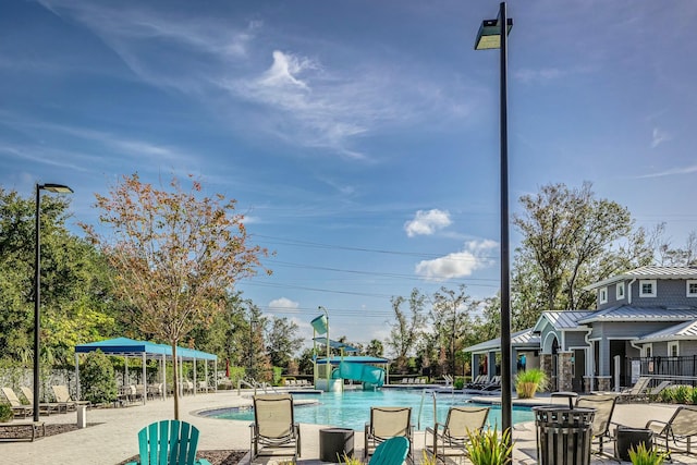 view of pool featuring a patio area and a water slide