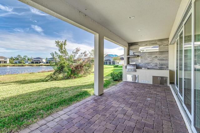 view of patio / terrace featuring area for grilling, a grill, and a water view