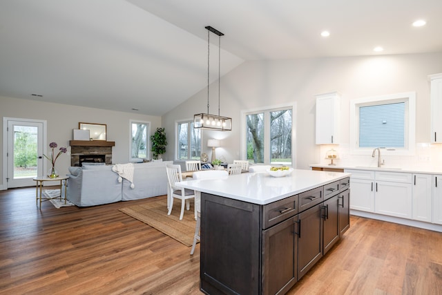 kitchen featuring sink, white cabinets, pendant lighting, and lofted ceiling