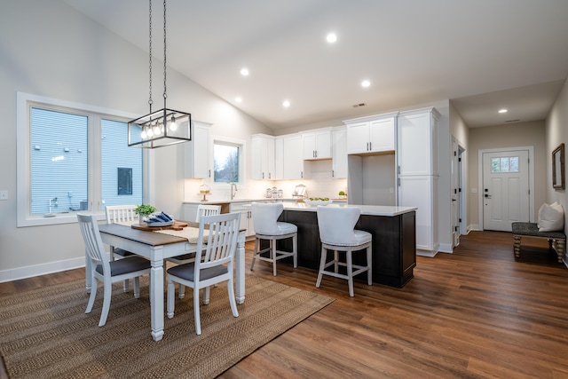 dining space featuring a healthy amount of sunlight, lofted ceiling, and dark wood-type flooring