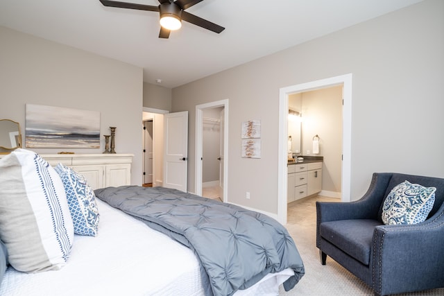 carpeted bedroom with ensuite bath, a spacious closet, a closet, and ceiling fan