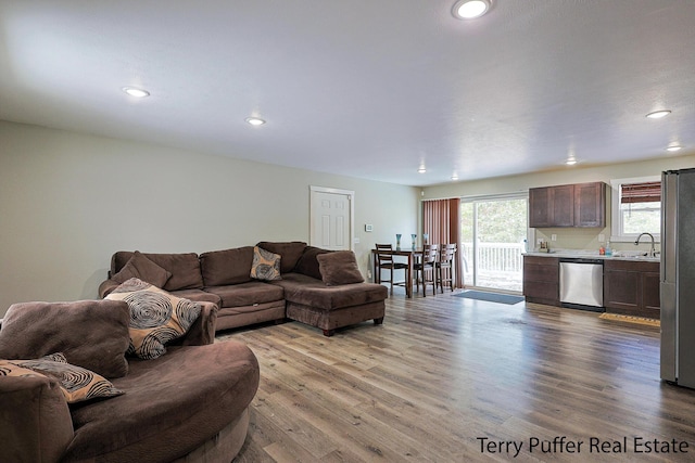 living room featuring light wood-type flooring and sink