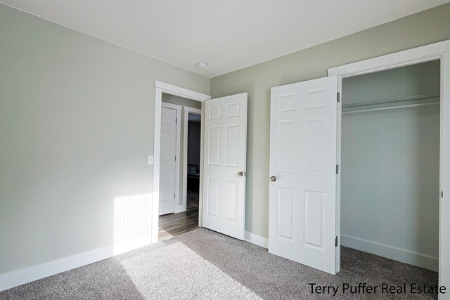 unfurnished bedroom featuring carpet floors and a closet