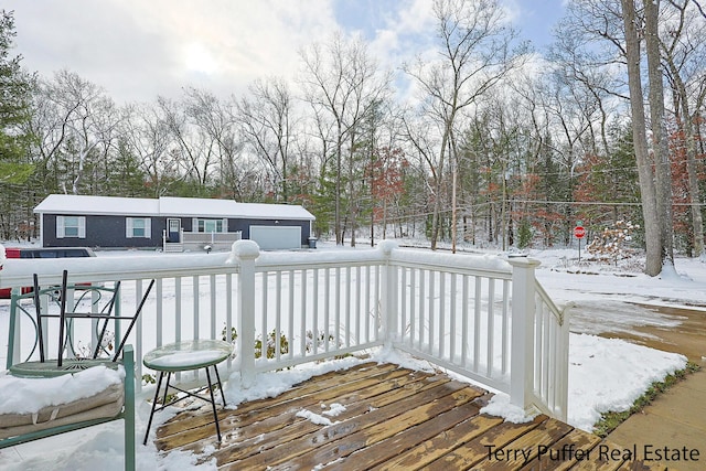 snow covered deck featuring a garage