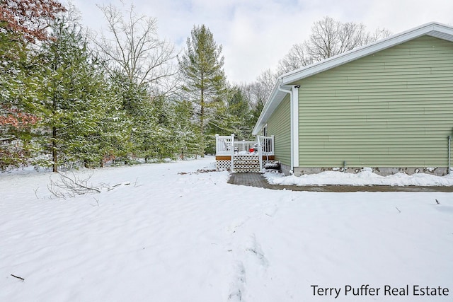 yard layered in snow with a deck