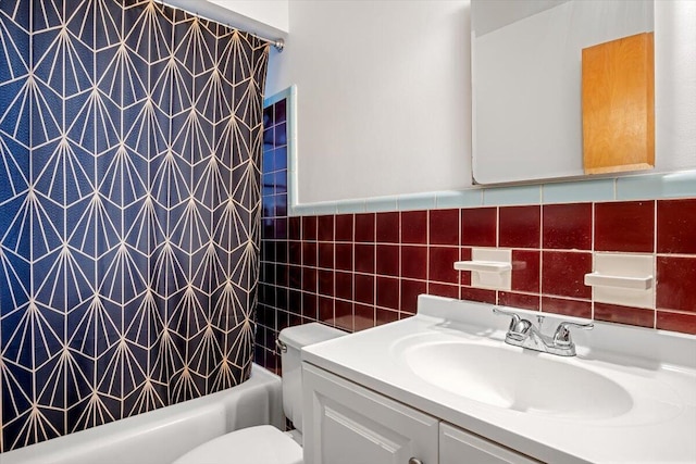 full bathroom with shower / bath combo, vanity, tile walls, and toilet