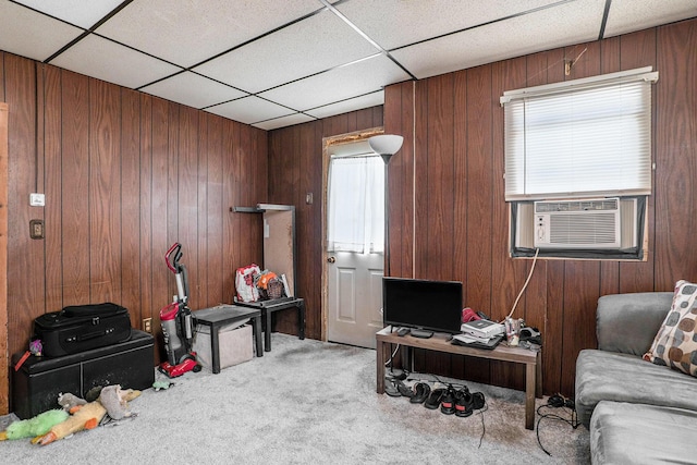 carpeted office space featuring a drop ceiling, wood walls, and cooling unit