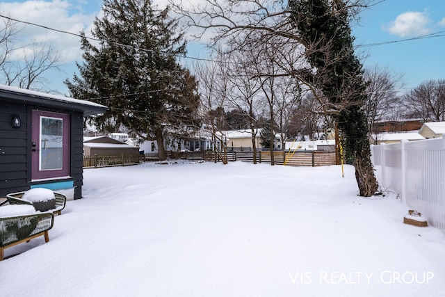 yard covered in snow with fence