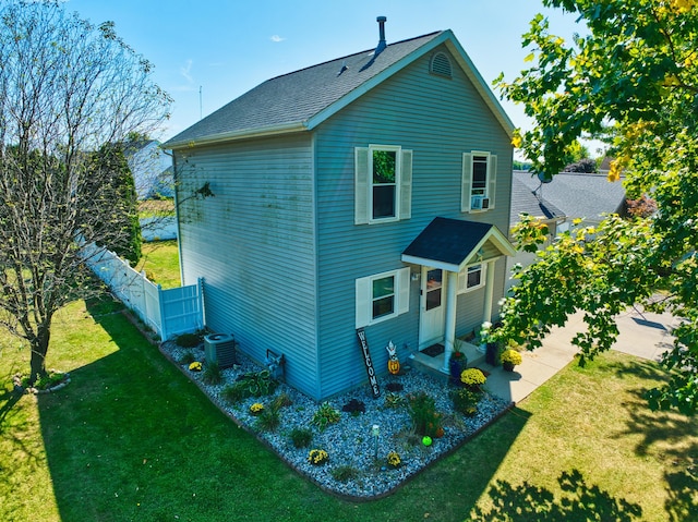 rear view of house featuring a lawn, central air condition unit, and cooling unit