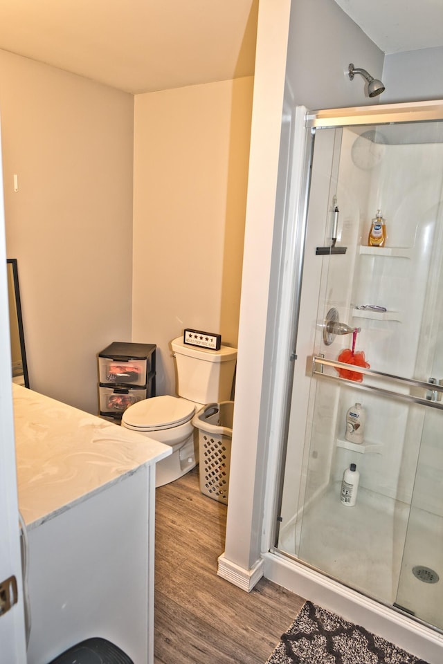 bathroom featuring hardwood / wood-style floors, vanity, toilet, and an enclosed shower