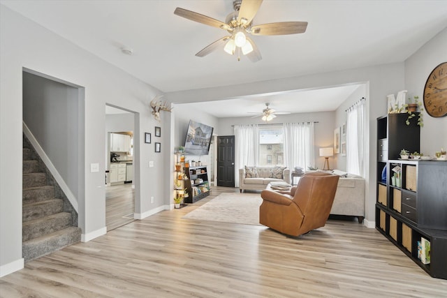 living room with ceiling fan and light hardwood / wood-style flooring