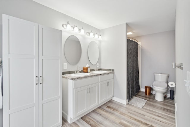 bathroom featuring hardwood / wood-style flooring, vanity, a shower with shower curtain, and toilet