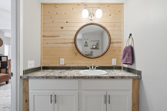 bathroom with vanity and wooden walls