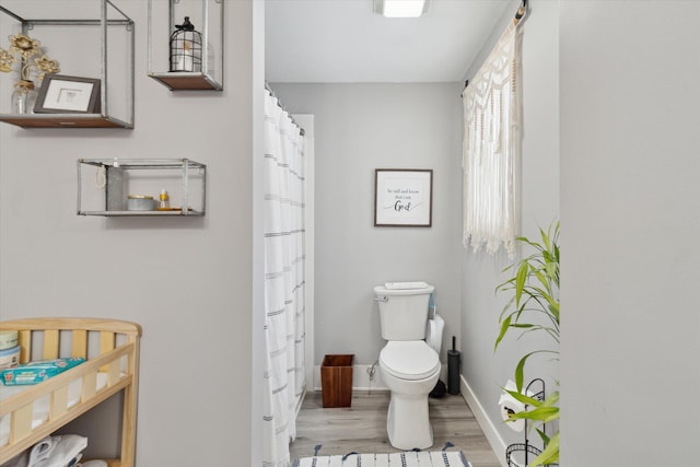 bathroom featuring toilet and wood-type flooring