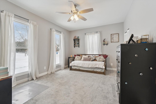 bedroom featuring ceiling fan, light carpet, and multiple windows