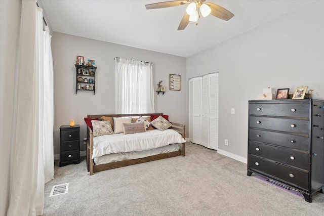 bedroom featuring ceiling fan, a closet, and light carpet