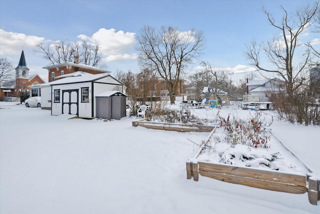 snowy yard featuring a storage shed