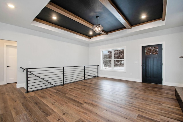 spare room featuring beamed ceiling, dark hardwood / wood-style flooring, and a tray ceiling