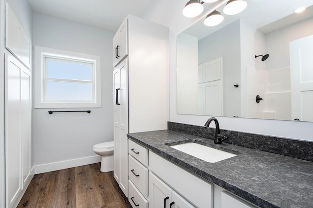 bathroom featuring vanity, hardwood / wood-style flooring, toilet, and walk in shower