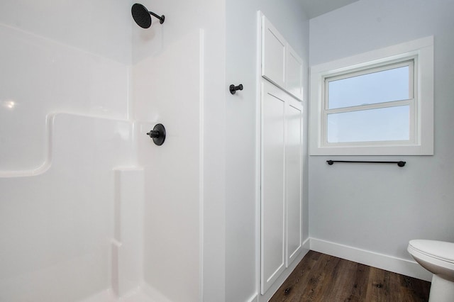 bathroom featuring hardwood / wood-style floors, toilet, and walk in shower