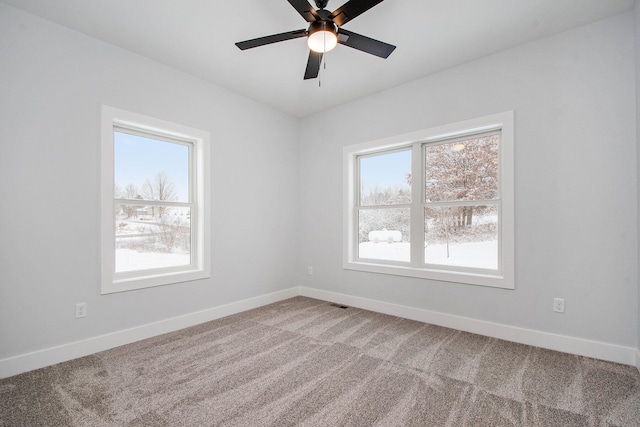 empty room with ceiling fan, plenty of natural light, and carpet floors