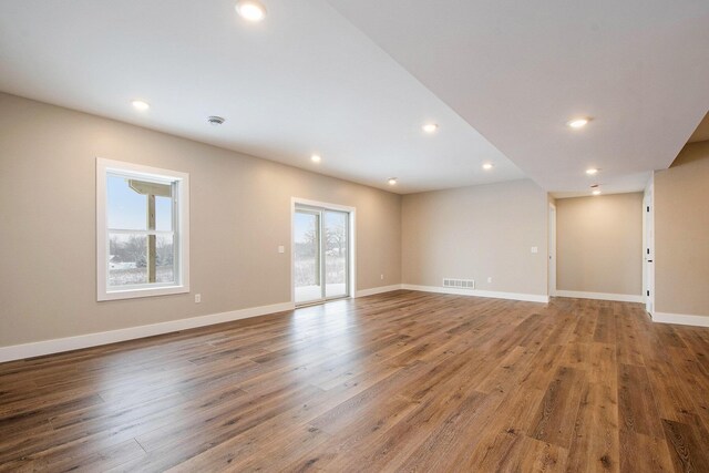 spare room featuring a healthy amount of sunlight and hardwood / wood-style flooring