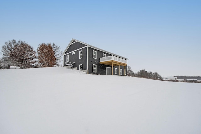 snow covered back of property featuring a deck