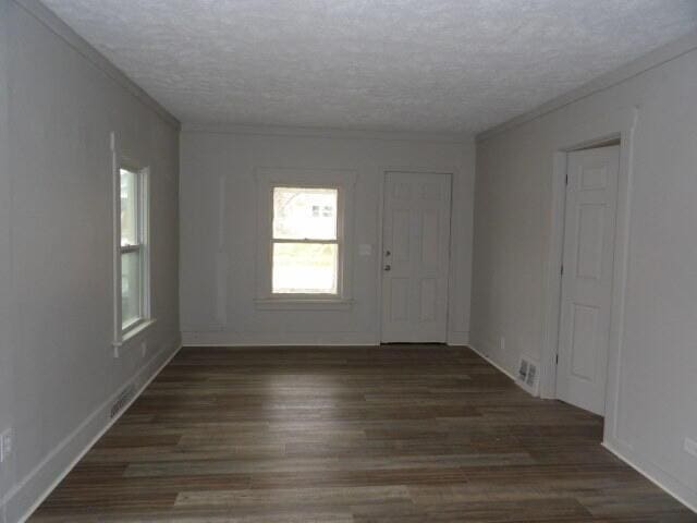 foyer featuring crown molding, dark hardwood / wood-style flooring, and a textured ceiling