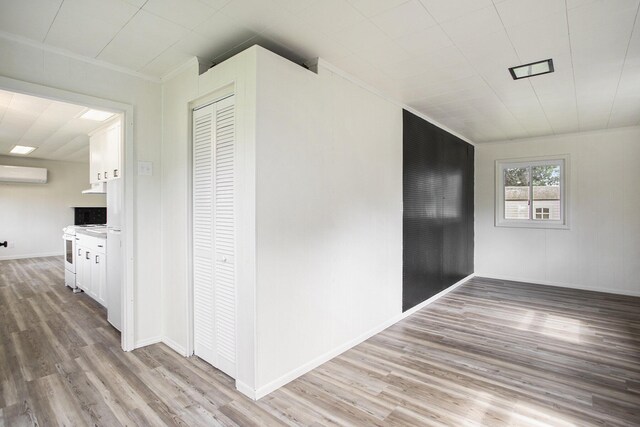 corridor featuring hardwood / wood-style flooring and a wall mounted AC