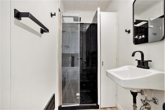 bathroom with crown molding, sink, and walk in shower