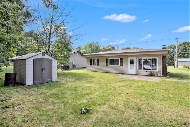 back of house featuring a lawn and a storage unit