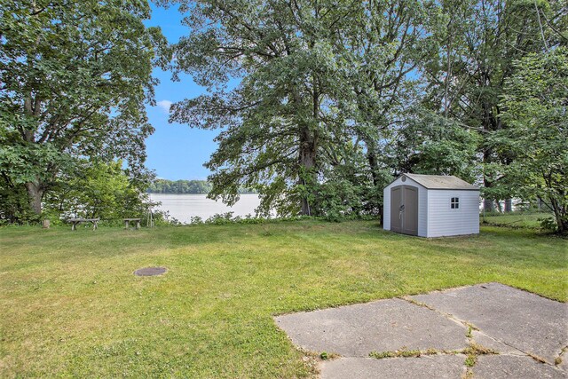 view of yard with a water view and a storage unit