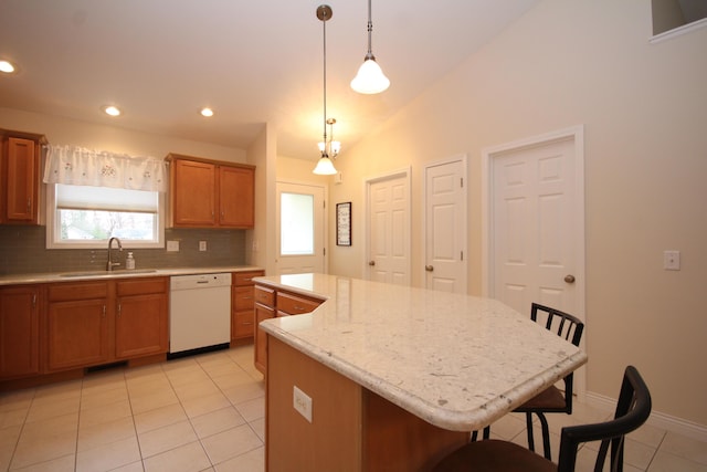 kitchen with dishwasher, a center island, a breakfast bar area, and sink