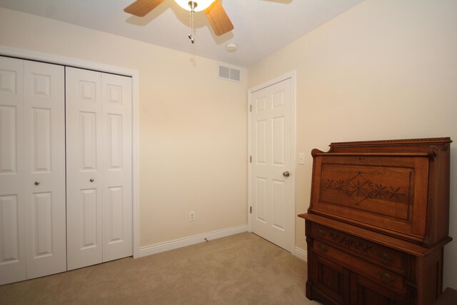 carpeted bedroom featuring ceiling fan and a closet