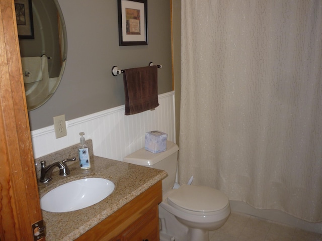 bathroom featuring tile patterned flooring, vanity, and toilet