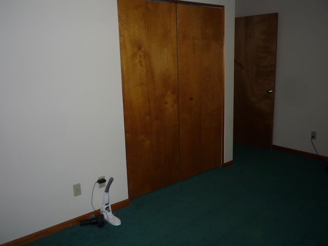 unfurnished bedroom with a closet and dark colored carpet