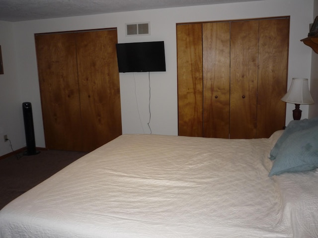 bedroom featuring two closets and a textured ceiling