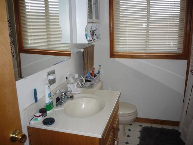 bathroom with vanity, toilet, and a healthy amount of sunlight