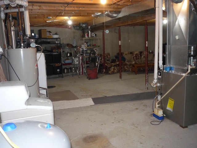 basement with washing machine and clothes dryer, heating unit, and gas water heater