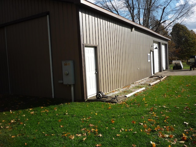 view of property exterior featuring a yard, an outdoor structure, and a garage