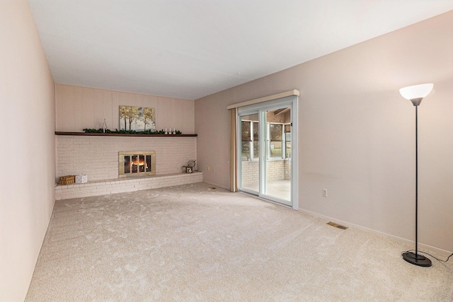 unfurnished living room with carpet flooring and a fireplace