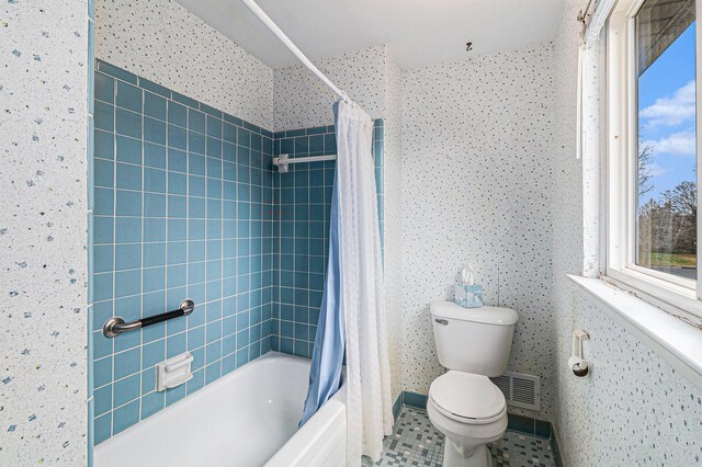 bathroom with shower / bath combo, toilet, and tile patterned floors