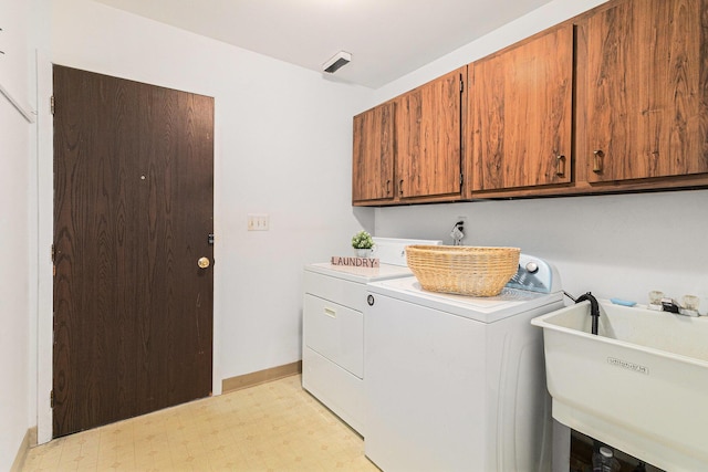 clothes washing area featuring cabinets, separate washer and dryer, and sink